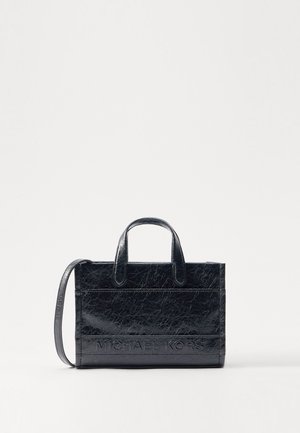 Czarna, teksturowana, skórzana prostokątna torebka z dwoma uchwytami i długim paskiem na ramię, z wytłoczonym napisem "Michael Kors" na przednim panelu.