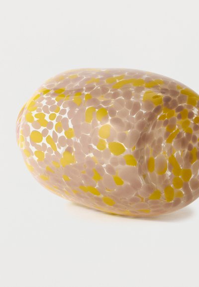Vase en verre de forme ovale, présentant des motifs tachetés translucides beige et jaune sur un fond blanc uni.