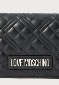 Clutch in pelle trapuntata nera con una placca metallica con il logo Love Moschino rettangolare centrata sulla parte anteriore.