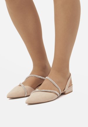 Scarpe a ballerina in suede nudo con punta appuntita, caratterizzate da cinturini scintillanti sulla parte anteriore e un'apertura sul retro, su un tacco basso a blocco.