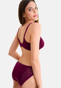 Bordeaux lingerie set met geometrisch patroon op de beha en bijpassende hoge slip. Gladde structuur met verstelbare bandjes en doorschijnende accenten.