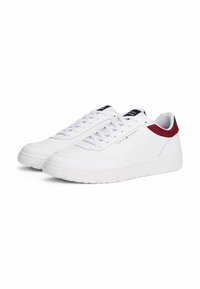 Witte leren sneakers met een gestructureerde afwerking, ronde neus en vetersluiting. Rood en marineblauwe accenten op de hak en de tong.