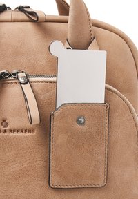 Bruine lederen handtas met een gestructureerde afwerking, voorzien van een zilveren kaarthouder in het zijvak en een metalen ritsdetail.