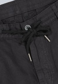 Black linen shorts featuring a drawstring closure with silver metal tips and a front button. Smooth texture with stitched waistband details.