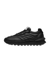 Sneaker in pelle nera con una texture liscia, forma arrotondata, suola spessa e chiusura con lacci. Presenta cuciture curve e un accento posteriore.