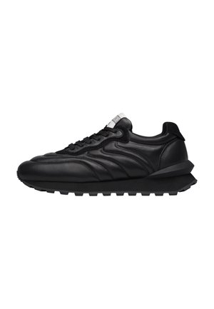 Sneaker in pelle nera con una texture liscia, forma arrotondata, suola spessa e chiusura con lacci. Presenta cuciture curve e un accento posteriore.