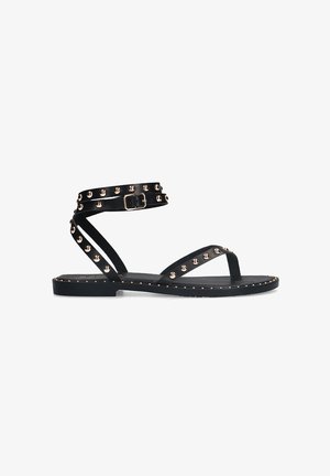 Zwarte platte sandalen met een enkelbandje, voorzien van rosegouden metalen studs en een gesp. Gladde textuur met een minimalistisch ontwerp en open teen.