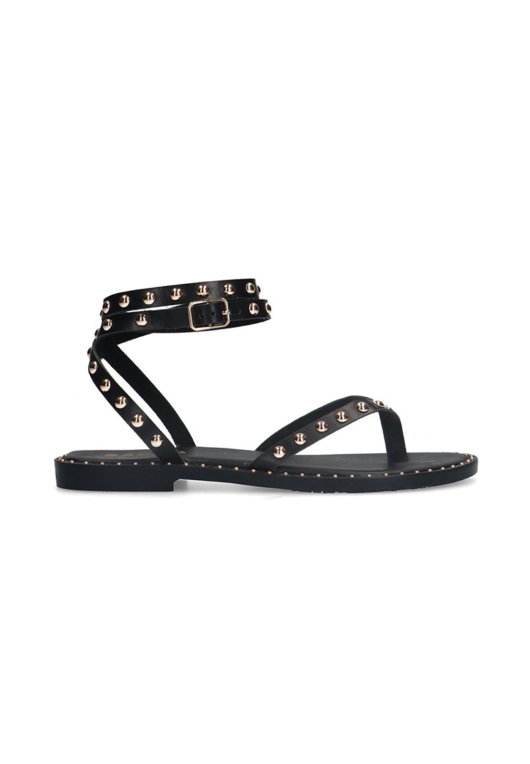 Zwarte platte sandalen met een enkelbandje, voorzien van rosegouden metalen studs en een gesp. Gladde textuur met een minimalistisch ontwerp en open teen.