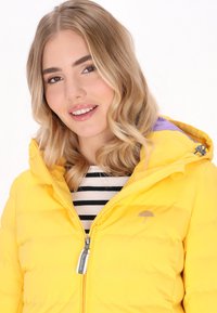 Gul puffjacka med huva, med en lila detalj på kragen, dragkedjestängning och en liten paraplylogotyp på bröstet.