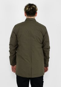 Giacca leggera verde oliva con una texture liscia, caratterizzata da un taglio dritto, maniche lunghe e un dettaglio di cucitura posteriore.