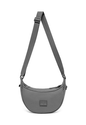 Grey crescent-shaped crossbody bag with adjustable strap and zipper closure, featuring a small rectangular front logo patch.