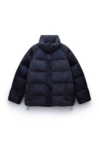 Námořnická pufovaná bunda s vysokým límcem, která kombinuje hladké a žebrované textury a má horizontální prošívání po celém těle.