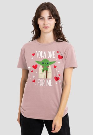 Helles rosa T-Shirt mit einem Cartoon-Yoda, umgeben von roten Herzen, und dem Text "YODA ONE FOR ME" in weißer Schrift. Kurze Ärmel und lockere Passform.