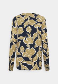 Blusa de manga larga con fondo marino y grandes patrones florales dorados, y un dobladillo curvado. La tela parece suave con un acabado ligeramente texturizado.