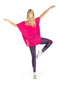 Losse roze top gecombineerd met galaxiethema leggings in donkere kleuren, met sterren en kosmische ontwerpen. Witte sneakers maken de look compleet.