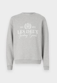 Lys grå sweatshirt med rund hals, med hvit trykt tekst "LES DEUX Sporting Goods" og en logo. Ribbestrikkede mansjetter og nederkant.