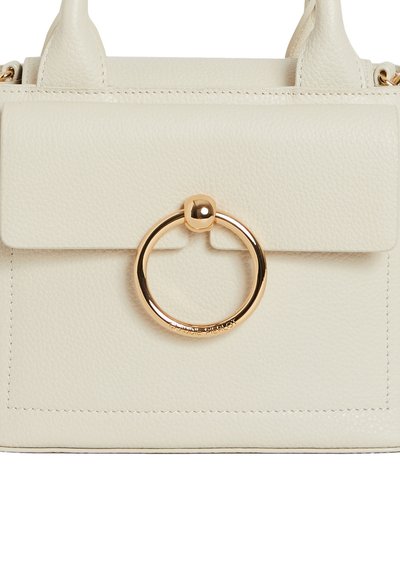 Borsa a mano in pelle crema con un accento in metallo dorato di forma circolare. Presenta una chiusura a pattina e dettagli di cucitura in vista. Dimensioni compatte.