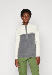 Fleece pullover met een witte bovenkant en een grijze onderzijde, voorzien van een hoge kraag en drukknoopsluiting, textuurstof en een logopatch.