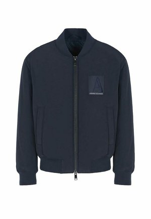 Giacca bomber navy con zip frontale, polsini a coste e logo a patch sul petto. Realizzata in un tessuto morbido con una texture liscia.