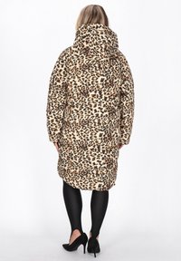 Leopardenmuster gepolsterter Mantel mit Kapuze, langen Ärmeln und seitlichen Taschen. Verfügt über eine taillierte Taille und ein knielanges Design. Dazu schwarze Leggings und High Heels.