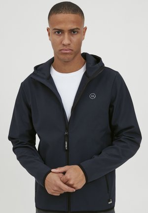 Marineblaues Kapuzenjackett aus weichem, glattem Stoff. Verfügt über einen frontalen Reißverschluss, seitliche Taschen und ein kleines Logo auf der Brust.