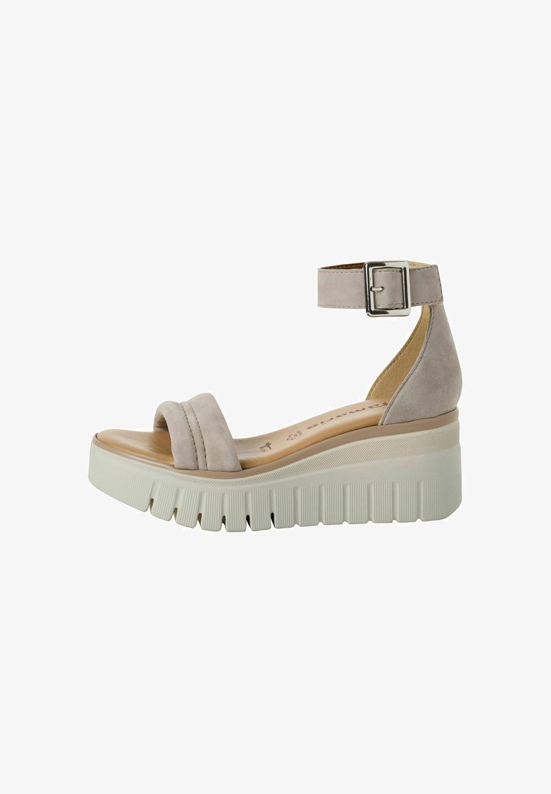 Sandale compensée en daim beige avec large bride à la cheville et boucle, bride rembourrée sur les orteils, et semelle épaisse en caoutchouc blanc à rainures profondes.