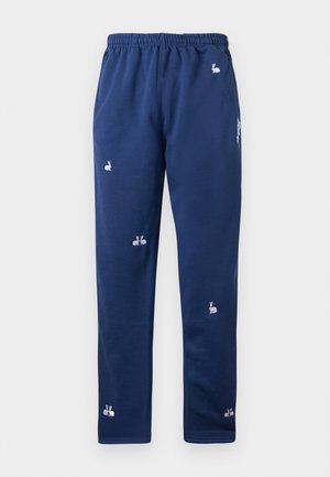 Pantaloni sport bleumarin cu talie elastică, având broderii albe cu iepurași distribuite pe toată suprafața și buzunare laterale.