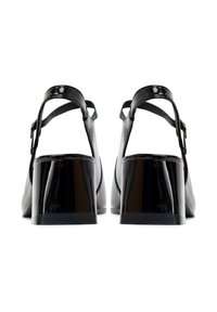 Sandalias con tacón de charol negro, con punta cerrada, correas en el tobillo y tacones gruesos. Textura suave y brillante sin patrones visibles.
