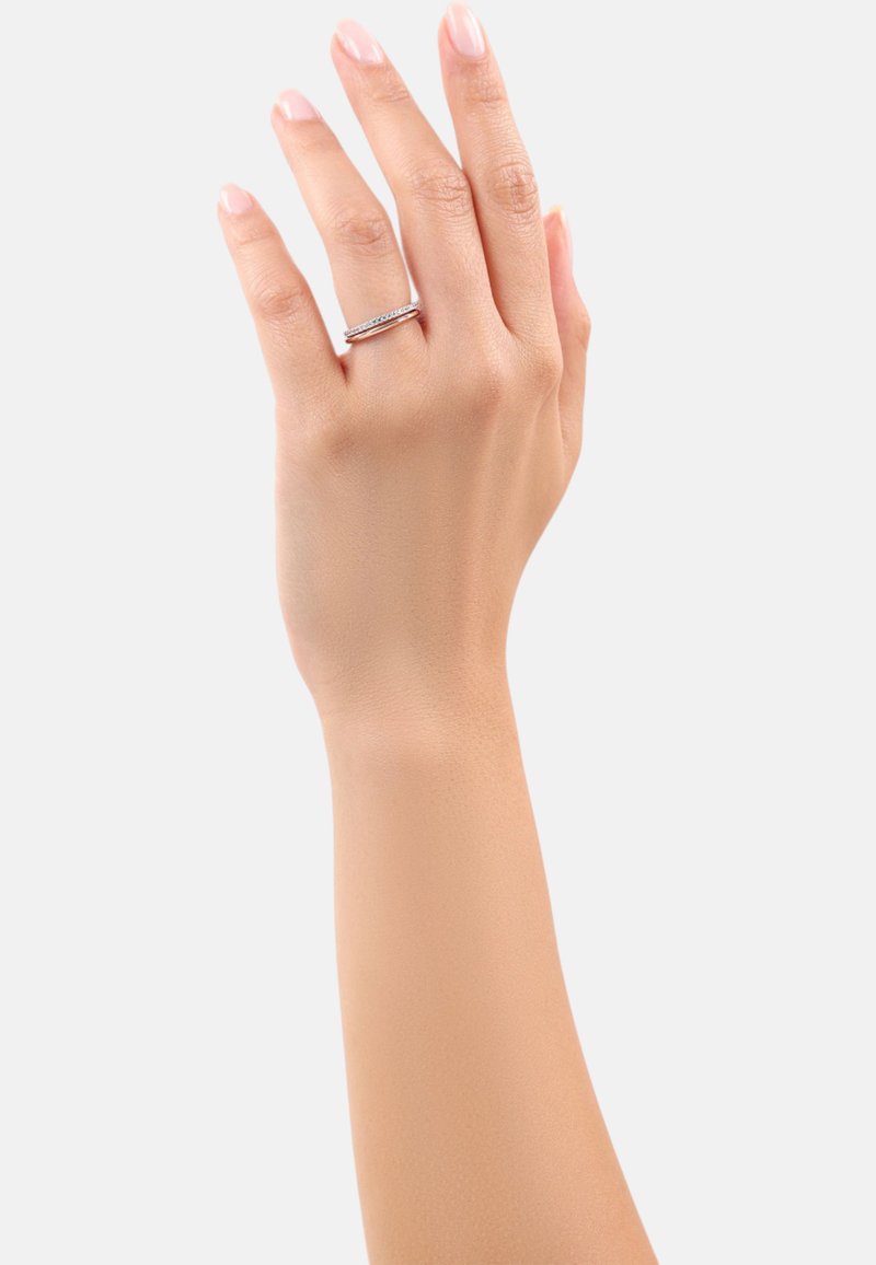 Anello d'argento con una fascia sottile e una fila di piccoli pietre trasparenti, indossato su una mano con un tono di pelle chiaro, su uno sfondo bianco semplice.