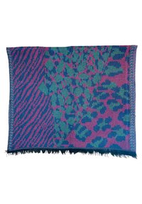 Couverture en tricot présentant un mélange de motifs abstraits verts, roses et bleu marine avec des variations de textures et des bords effilochés, en forme rectangulaire.