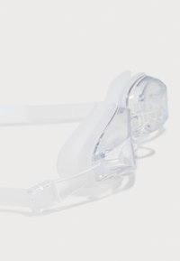 Lunettes de natation claires avec un cadre en silicone blanc doux, une sangle réglable et des verres transparents pour un ajustement sûr et confortable.