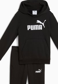 Ensemble de sweat à capuche et pantalon noir en tissu doux. Le sweat à capuche dispose d'une poche avant et d'un logo PUMA blanc sur la poitrine et la jambe.
