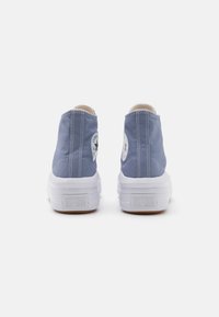 Niebieskie trampki na wysokiej podeszwie z białą gumową podeszwą, z klasycznym logo po bokach i kontrastującymi detalami szwów.