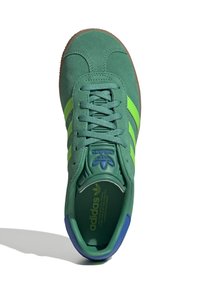 Zelené semišové tenisky s limetkovými pruhmi, okrúly špička, textúrovaný interiér a modré akcenty na jazyku a päte. Podrážka z gumy.