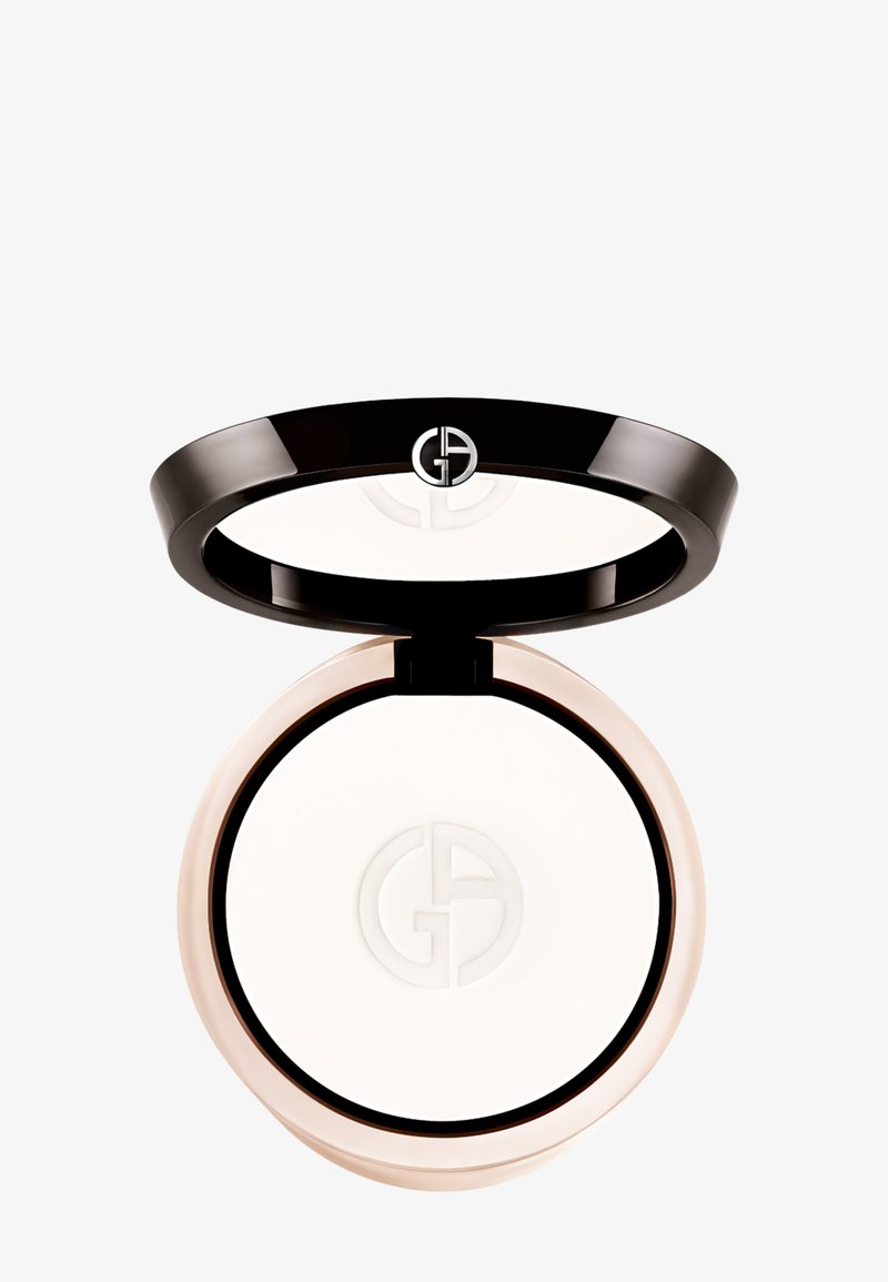 Polvo compacto en un estuche circular negro con un espejo y un polvo blanco en su interior, presentando un logotipo elevado en la superficie.