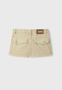 Mini-jupe en denim beige avec deux poches arrière à rabat avec boutons et une petite étiquette de marque en cuir marron sur la ceinture.