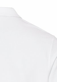 Kortærmet hvid polo-shirt med krave, lavet af vævet bomuldsstof, med en tekstureret overflade og subtile sømdetaljer.