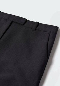 Pantalon formel noir avec passants de ceinture et poches latérales, présenté à plat sur un fond gris clair.