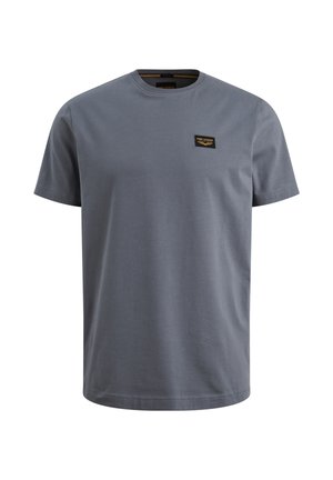 Sivá bavlnená tričko s krátkymi rukávmi, okrúhlym výstrihom a malou čiernou a zlatou nálepkou na hornej ľavej strane. Hladká textura.