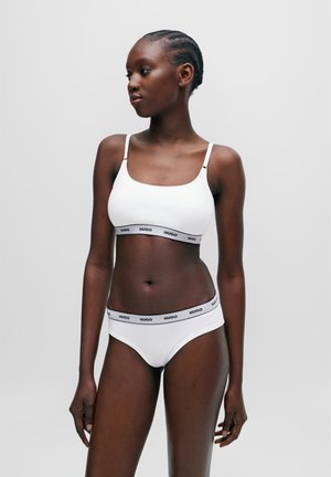 Ensemble bralette et bikini en coton blanc avec un bandeau noir portant le logo "HUGO". Design simple et ajusté avec des bretelles fines et une texture lisse.
