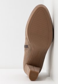 Fawninruske nahkasaappaat, joissa on teksturoidun kumipohjan, sivuvetoketju ja matala korko. Suunniteltu vakauden ja mukavuuden takaamiseksi.