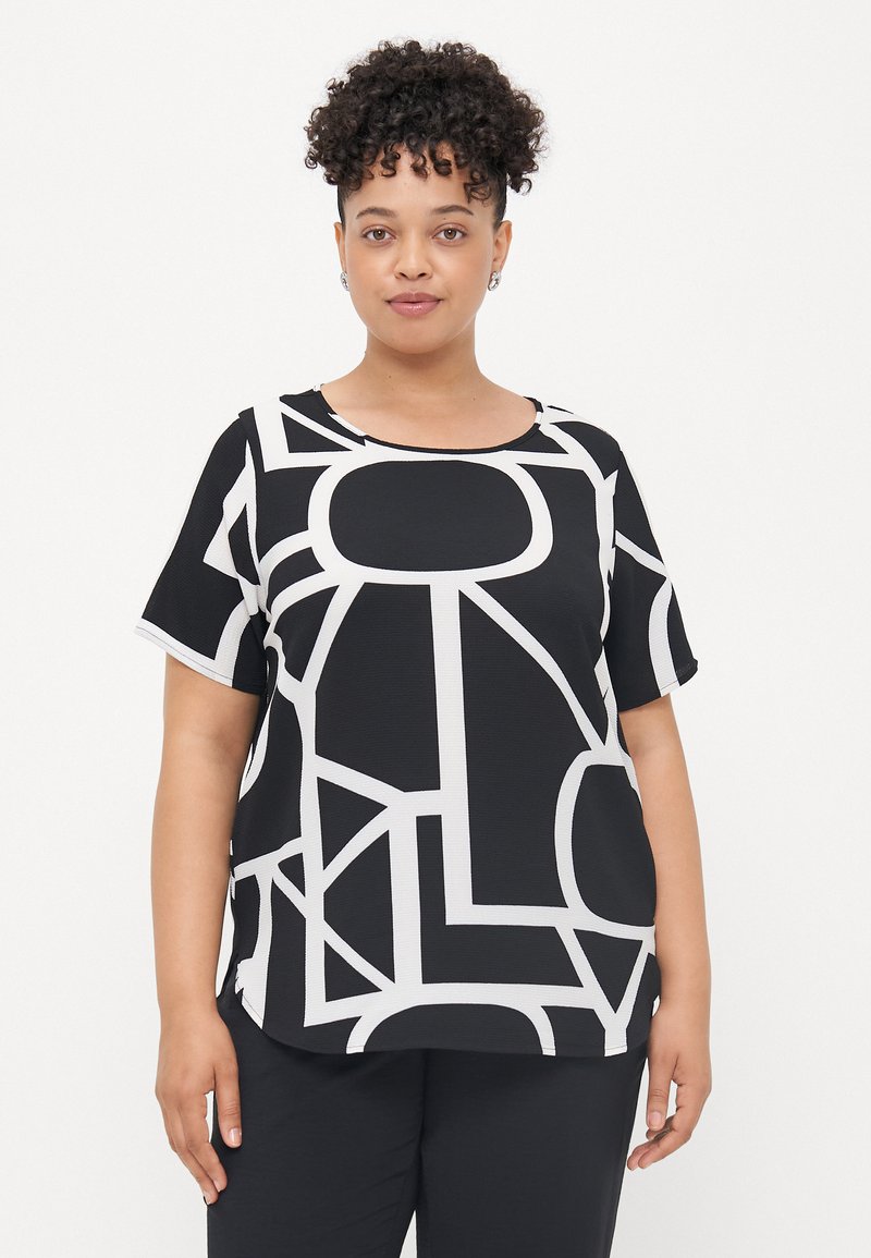 Black and white top featuring geometric patterns, short sleeves, round neckline, and a relaxed fit. Made from textured fabric.