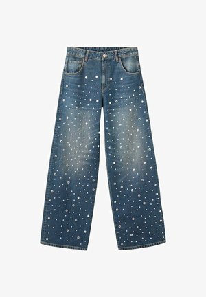 Wide-leg denim jeans in dark blue with a faded finish, featuring silver metallic studs arranged in a polka dot pattern across the fabric.