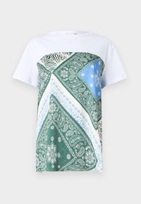 T-shirt blanc avec un panneau à motifs vert, bleu et crème présentant des motifs paisley et des rayures de zèbre sur la partie supérieure avant.