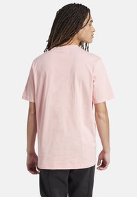 Hellrosa Baumwoll-T-Shirt mit kurzen Ärmeln und Rundhalsausschnitt, mit lockerer Passform und minimalistischem Design.