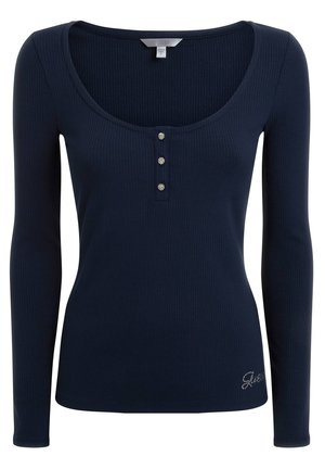 Maglietta a maniche lunghe navy realizzata in tessuto a coste, con scollatura a barca, tre bottoni decorativi e ricamo discreto all'orlo.