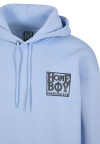 Light blue hoodie with drawstrings and black logo text "HOME BOY loud.couture" on the left chest area.