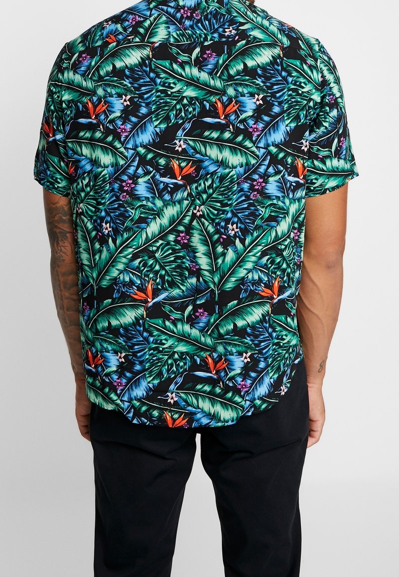 Kurzärmliges Hemd mit schwarzem Hintergrund, grünen tropischen Blättern, orangen Blumen und lila Akzenten, aus leichtem Stoff hergestellt.