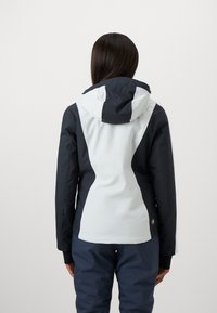 Rückansicht einer zweifarbigen Jacke mit einem navyblauen oberen Abschnitt und einem hellgrauen unteren Abschnitt, mit Kapuze und schlanker Passform. Keine sichtbaren Beschläge.