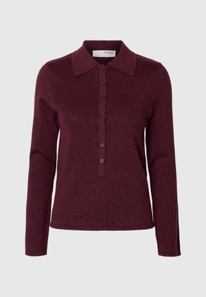 Sieviešu garām piedurknēm burgundijas krāsas adīta polo krekls ar pogu aizdari un klasisku apkakli, uz gaiši pelēka fona.